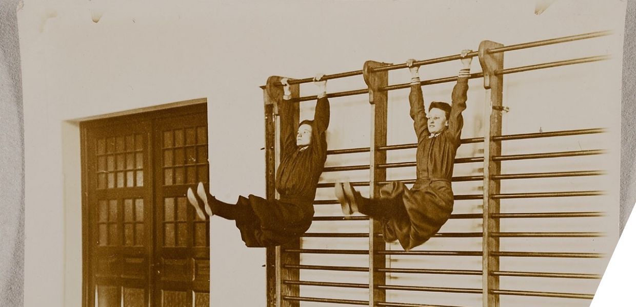 Two people doing exercises on wall bars