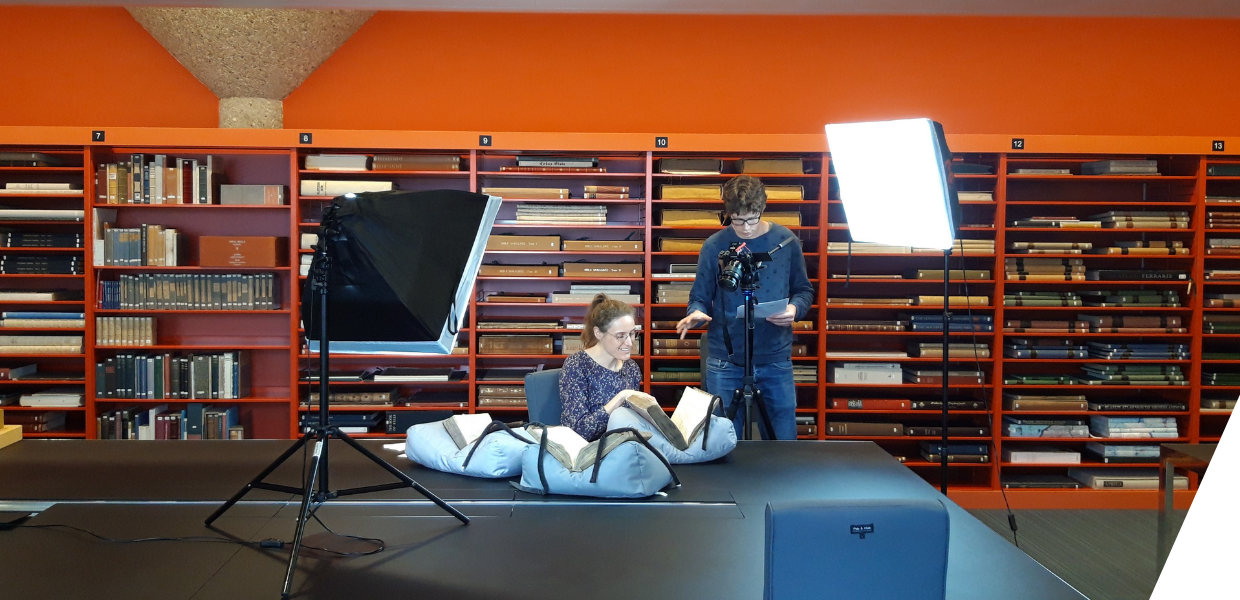 People making a video in a library, showing books