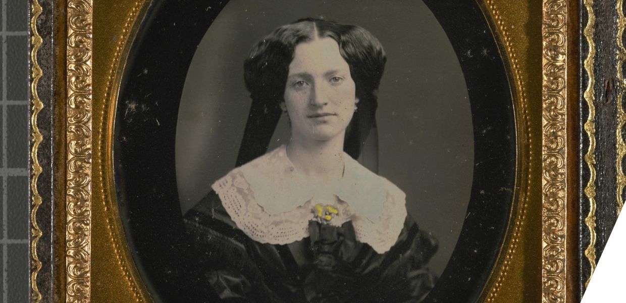 Studio portrait of a young woman wearing a jeweled lace collar.