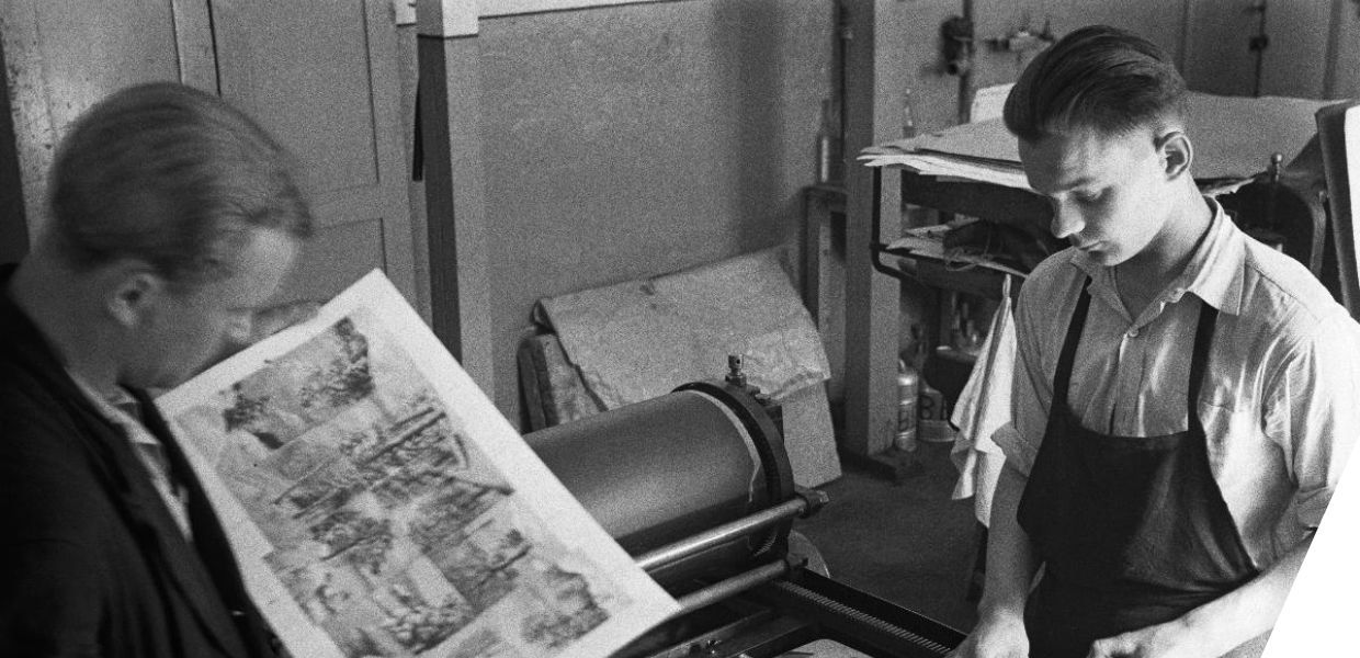 Two men stood at a large printing machine