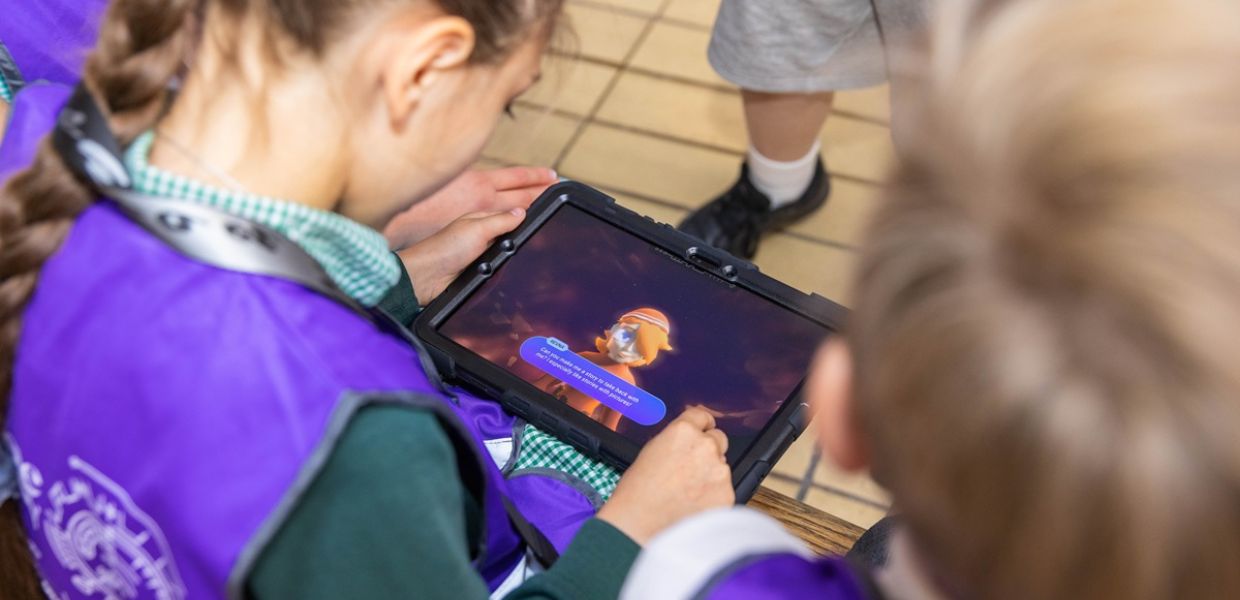 Children play with a Time Odyssey avatar on a tablet. 
