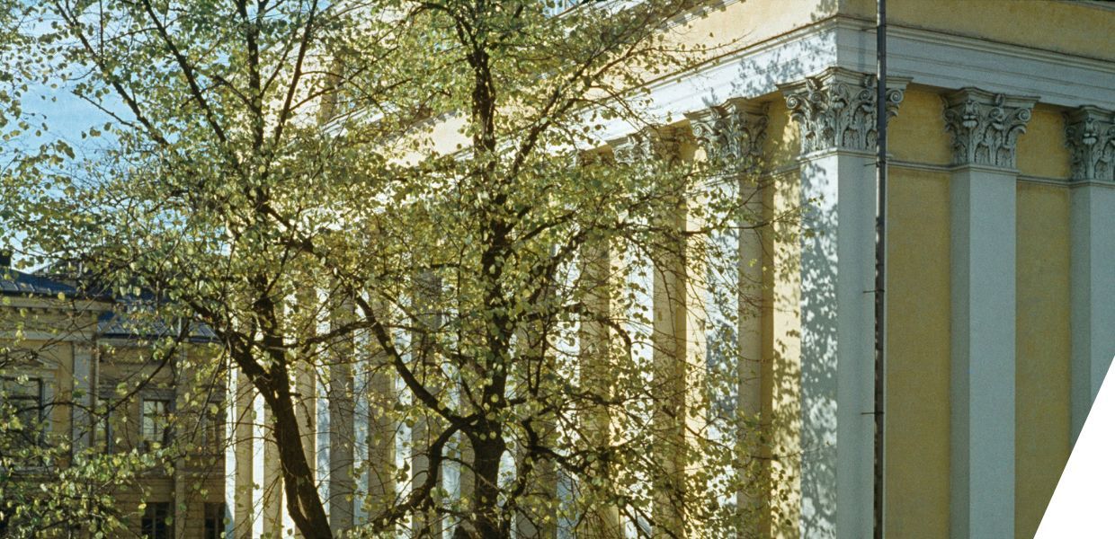 Tall Corinthian columns line the sunlit façade of a neoclassical building